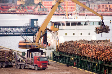 Truck and ship at docks with pulpwood cargo