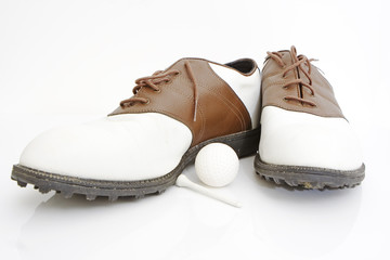 golf shoes ball and tee isolated against white background