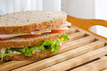 submarine sandwich with whole grain bread on wood platter
