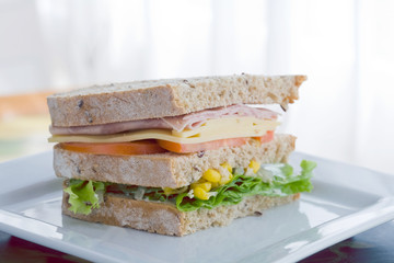 submarine sandwich with whole grain bread on wood platter