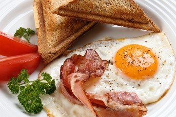 Breakfast - toasts, egg, bacon and vegetables