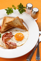 Breakfast - toasts, egg, bacon and vegetables