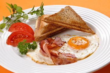 Breakfast - toasts, egg, bacon and vegetables
