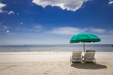 sunny beach with green umbrella