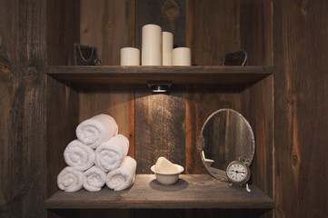 Rustic Spa Scene with Towels, Soap, Mirrors, Candles and Clock.