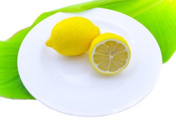 Whole and a lemon half on a white plate