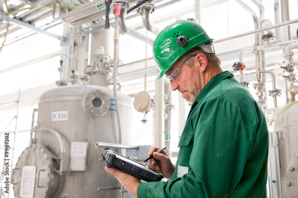 Wall mural Middle aged industrial worker with notebook