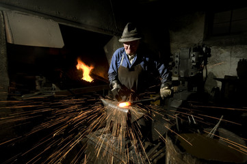 Schmied hämmert am Amboß bis die Funken fliegen querformat