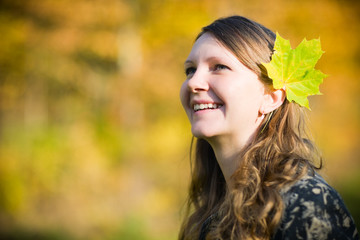 Beautiful young woman in a park at sunny fall day