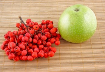 Ashberry and green apple on wooden background