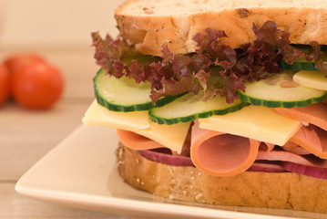 Fresh ham, cheese & salad sandwich on rustic table