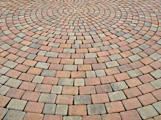 two-colored paving stone creates circular pattern on a plaza