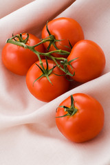 Bunch of sweet red tomatoes on lien table-cloth