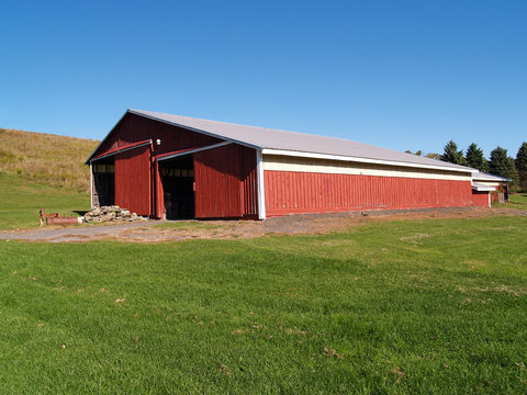 view of a large red barn in the country