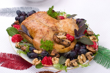 Garnished roasted duck on Christmas decorated table.