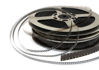 stack of old movie films on metal reel on white