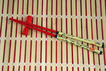 red chopsticks with support on a bamboo serviette