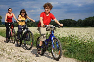 Fototapeta premium Family riding bikes in rural scenery
