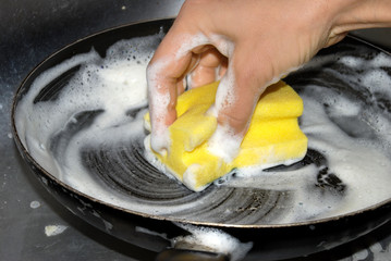 woman hand washing frying pan closeup