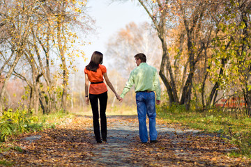 Young happy couple walking in the autumn park