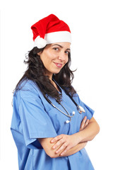 Friendly female doctor in blue scrubs with christmas hat