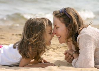 câlin entre mère et fille sur la plage - obrazy, fototapety, plakaty