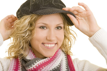 Lachende blonde Frau setzt sich eine Schiebermütze auf