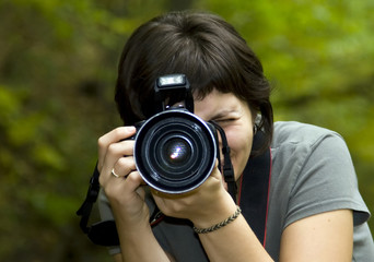 Young female photographer in forest