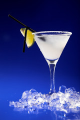 cocktail with lime and ice on blue