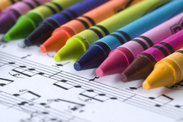 A child's crayons and music score