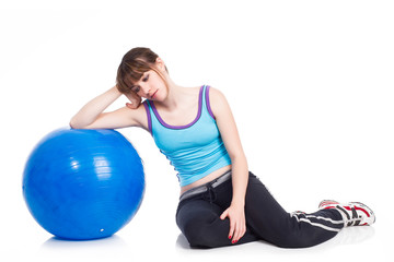 Fototapeta na wymiar Young woman lying down on a blue exercise ball