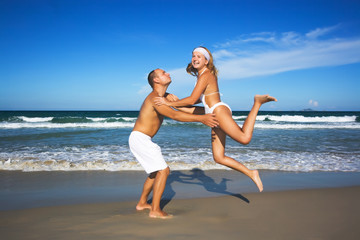 Young couple have a fun time on the tropical beach.