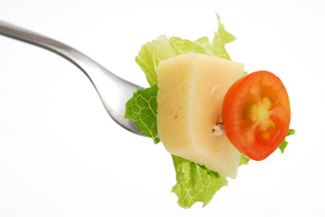Cheese and veggies picked with fork isolated on white