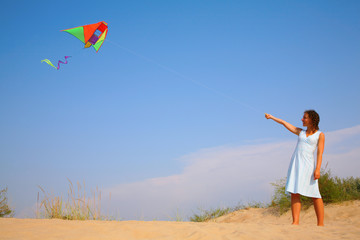 Girl in  white dress runs kite