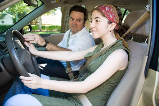 Teen girl taking driving lessons from an instructor
