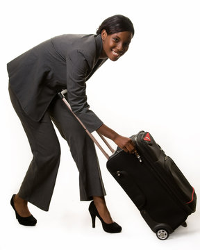 Full body of woman in grey business suit bending  suitcase