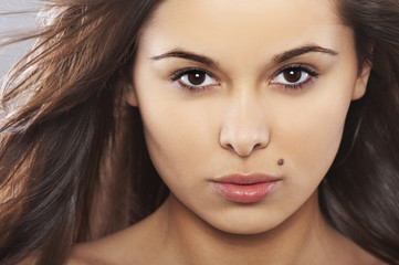 Obraz premium natural and beautiful girl with winblowed hair on light