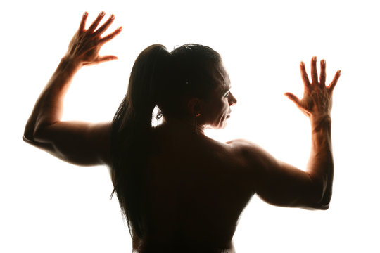 Silhouette of woman bodybuilder from back with fingers