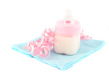 pink baby girl bottle on blue napkin with curled ribbon