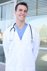 A young handsome doctor smiling outside hospital