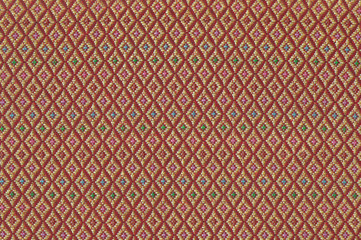 Intricate pattern of a red and gold Songket cloth