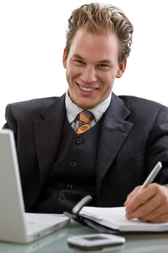 Businessman working on laptop computer, smiling,