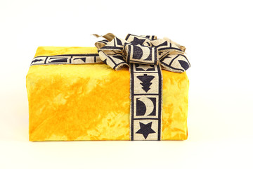Christmas present in yellow original paper with beautiful tie