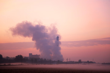 Fototapeta premium Smoking Chimney during sunrise