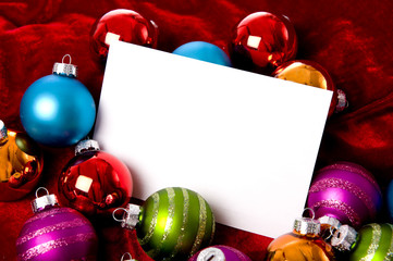 A group of colorful Christmas baubles  a white notecard
