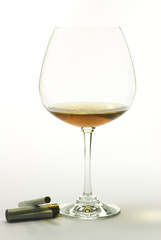 Brandy and cigarette on white background