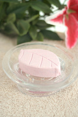 pink leaf shaped decorative soap on a bath towel with leaves