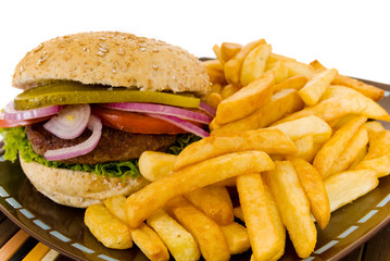 Hamburger with salad, pickle, onions, tomato and  fries.