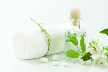 Jar with fresh leaves, flowers and towel (SPA concept).