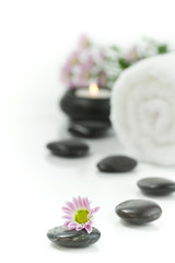 Fototapeta na wymiar Pebbles, candle, towel and flowers. Selective focus